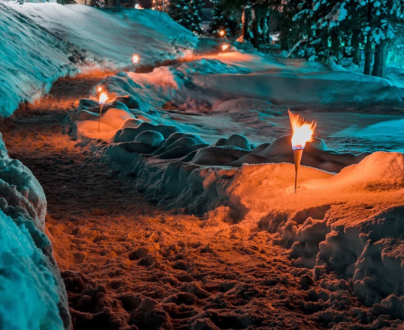 Schneebedeckter mit Fackeln beleuchteter Pfad